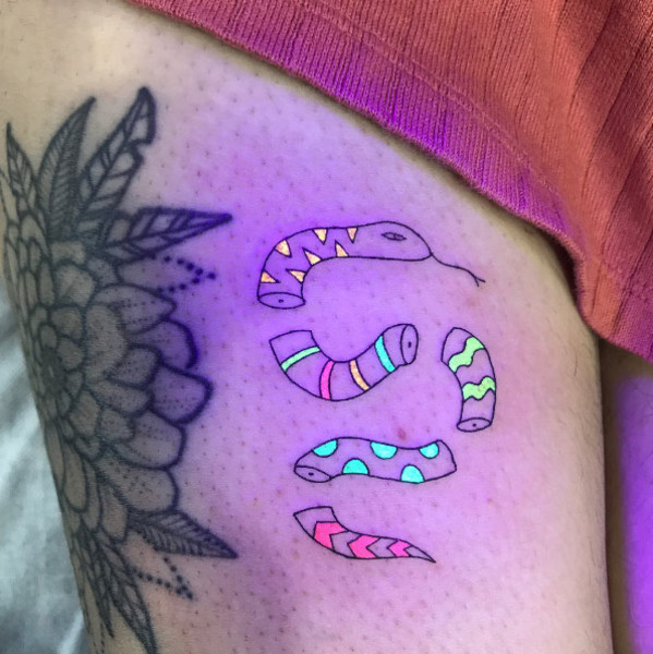 Image of a newly applied blacklight tattoo on an arm, covered with a SecondSkin bandage to protect it during the initial healing process.