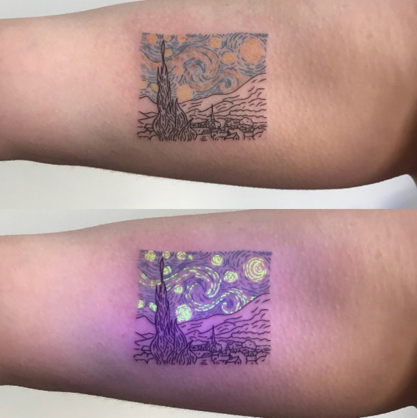 A person showcasing their glowing black light tattoo under UV light in a dimly lit environment, highlighting the magical effect.