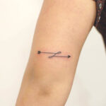 Arrow tattoo on tricep for strength and direction