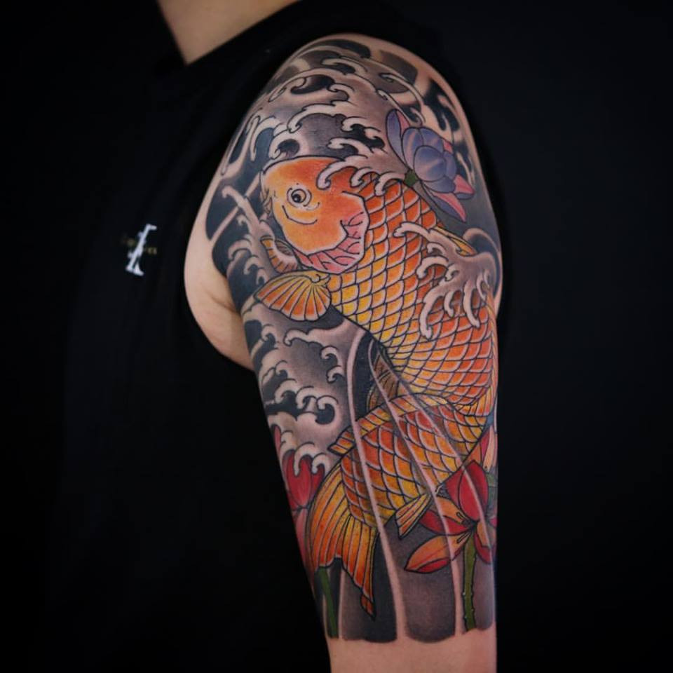 Koi and lotus half sleeve tattoo by Ning Chula, showcasing the harmonious pairing of koi and lotus, both symbols of perseverance and positive transformation.