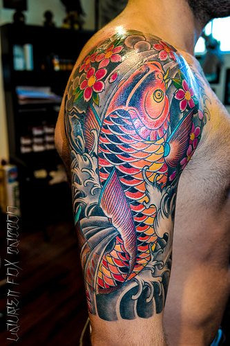 Koi and Cherry blossom sleeve tattoo by Lauren Fox, a vibrant and colorful sleeve demonstrating the popular combination of koi fish and sakura.