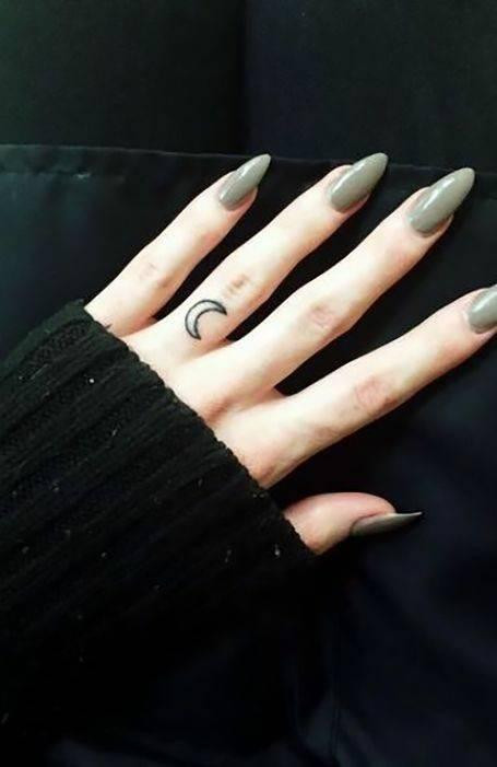 Crescent moon ring finger tattoo