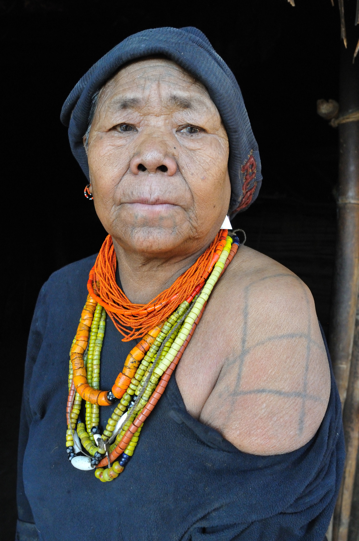 Daw Paa Taung Te, a Macham elder displaying her shoulder tattoos, received around age 18. These tattoos signified adulthood and readiness for marriage in Macham culture.