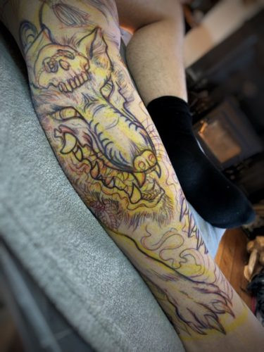 Early stage of the Kitsune tattoo, showing the initial linework and the emerging form of the design