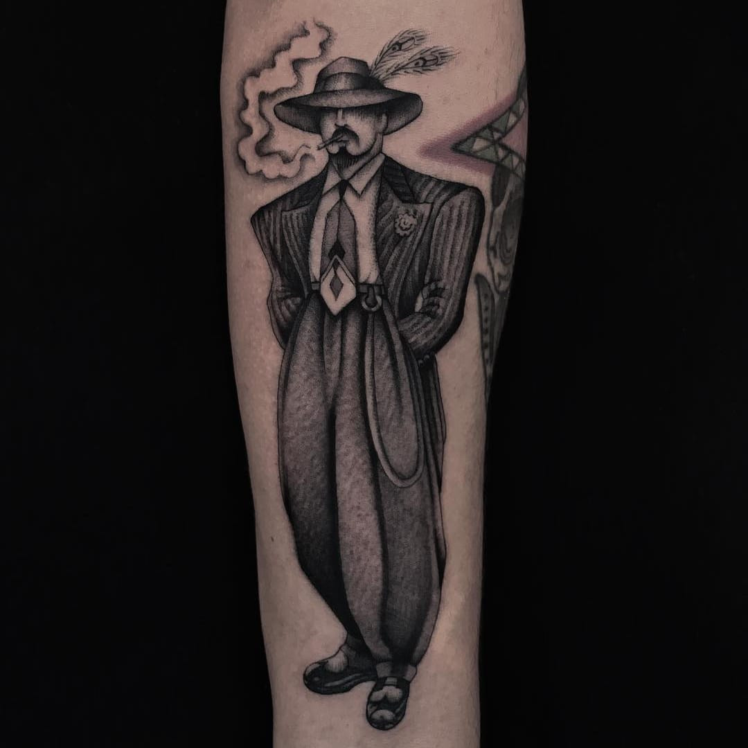 Tattoo by Illegal Tattoos. Zoot Suit era Chicano tattoo by Illegal Tattoos depicting a portrait in black and grey, representing the historical Pachuco and Zoot Suit culture influence on Chicano tattoo art.