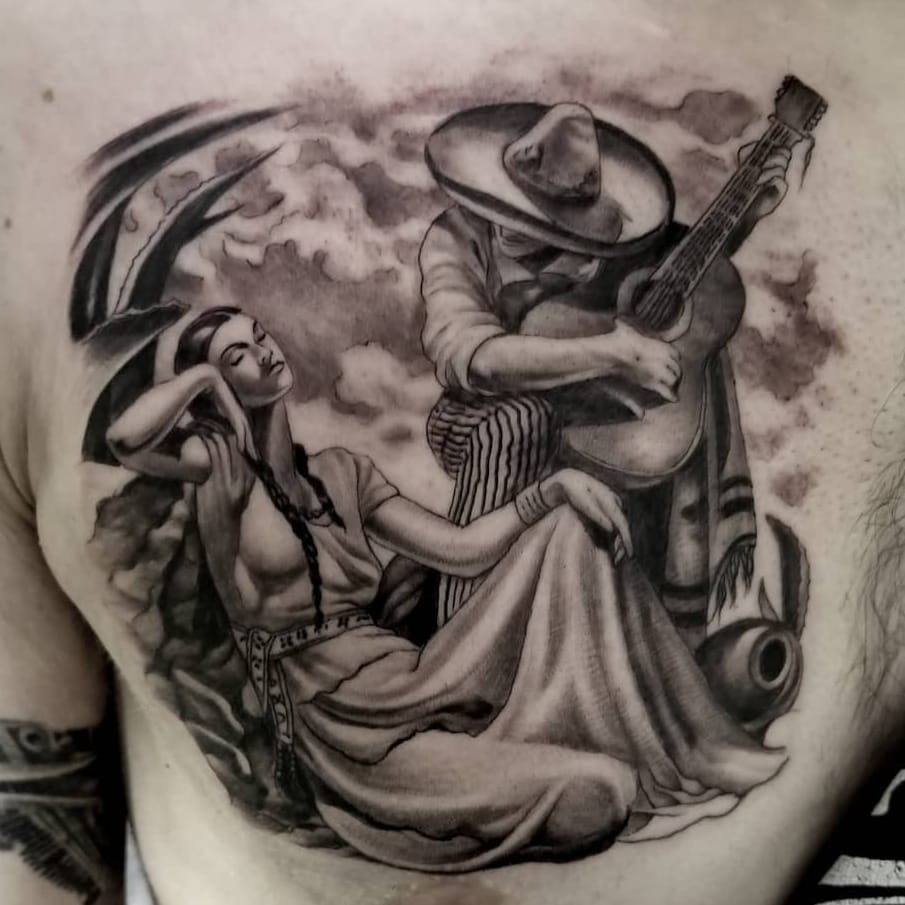 Tattoo by Freddy Negrete. Iconic Chicano tattoo by Freddy Negrete showcasing a lady with a guitar, inspired by Jesus Helguera's art, in black and grey, demonstrating the influence of Mexican art on Chicano tattoo style.