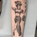 Classic female pin-up tattoo in traditional style, showcasing bold lines and vibrant colors.