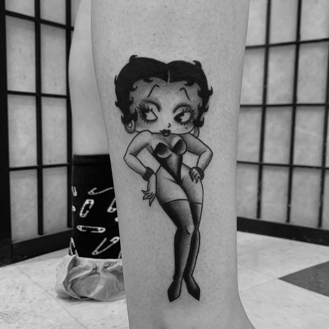 Neo-traditional female pin-up tattoo with bold lines and vibrant colors, inspired by burlesque themes.