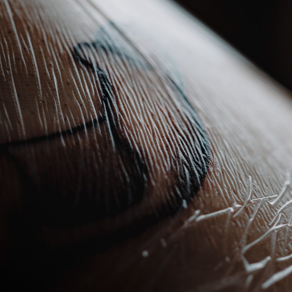 Saniderm bandage on arm, showcasing a vibrant, healed tattoo underneath