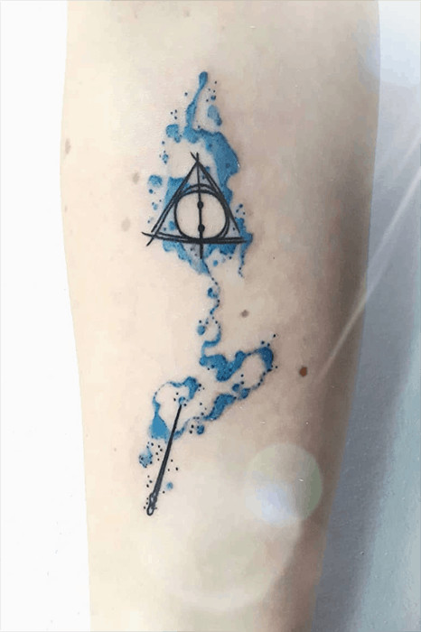 Two-color wand tattoo with sketched Deathly Hallows, combining artistry and key Harry Potter symbols