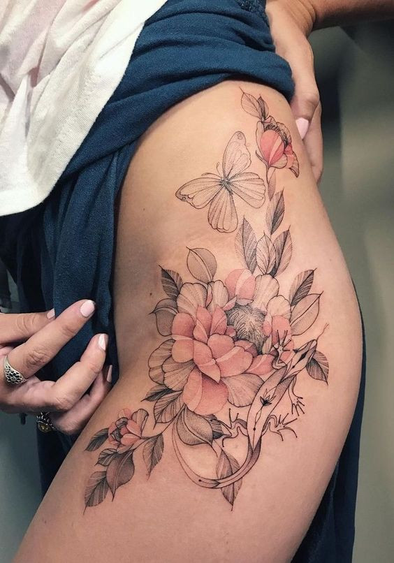 Floral and butterfly thigh tattoo with pink flowers and leaves, showcasing detailed and elegant body art design.