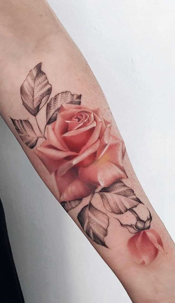 Realistic red rose tattoo with detailed shading on inner forearm, featuring black and grey leaves.