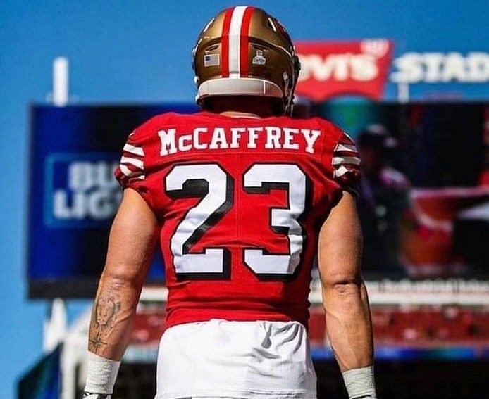 Close-up of Christian McCaffrey's arm tattoos featuring a lion, sword, compass, and mountain range.