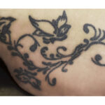 Arabesque butterfly tattoo design on the right hip, showcasing intricate line work and placement ideas for women.