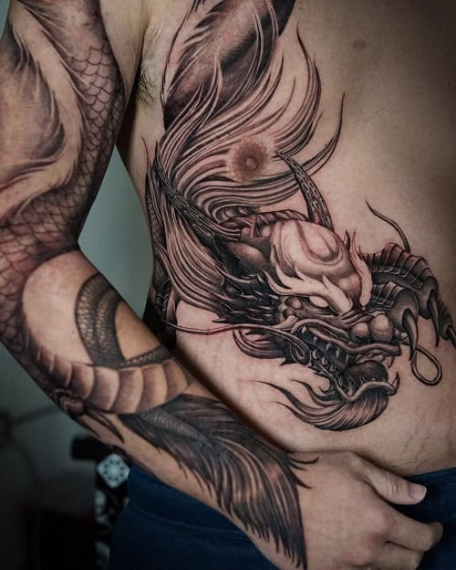 Powerful 3D dragon tattoo winding along the arm, showcasing depth and intricate scales.