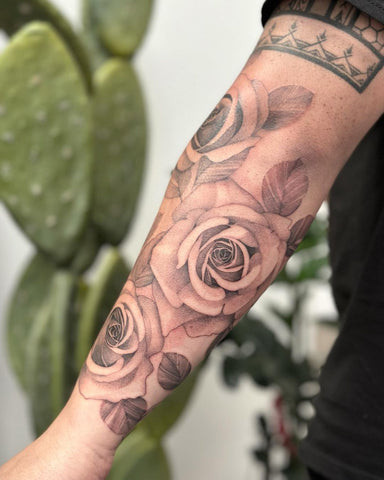 Forearm tattoo with three roses arranged in a cluster, symbolizing balance, harmony, and significant relationships or life phases.