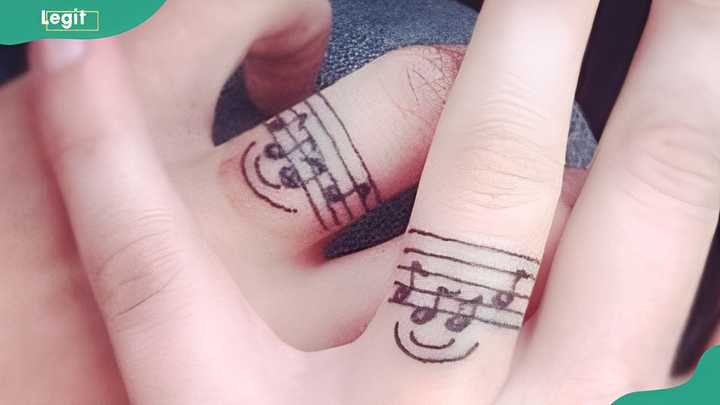 Musical notes ring tattoo expressing a shared love for music and harmonious relationship.