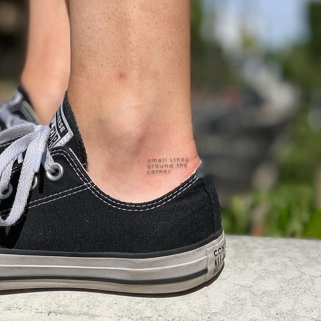 Close-up of Amanda's arm tattoo, a detailed line drawing of a house, her childhood home, evoking nostalgia and memories of the past.