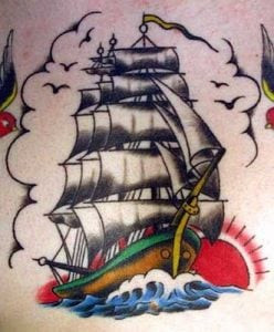 Detailed tattoo of a fully rigged ship, showcasing the artistry and complexity of nautical designs.