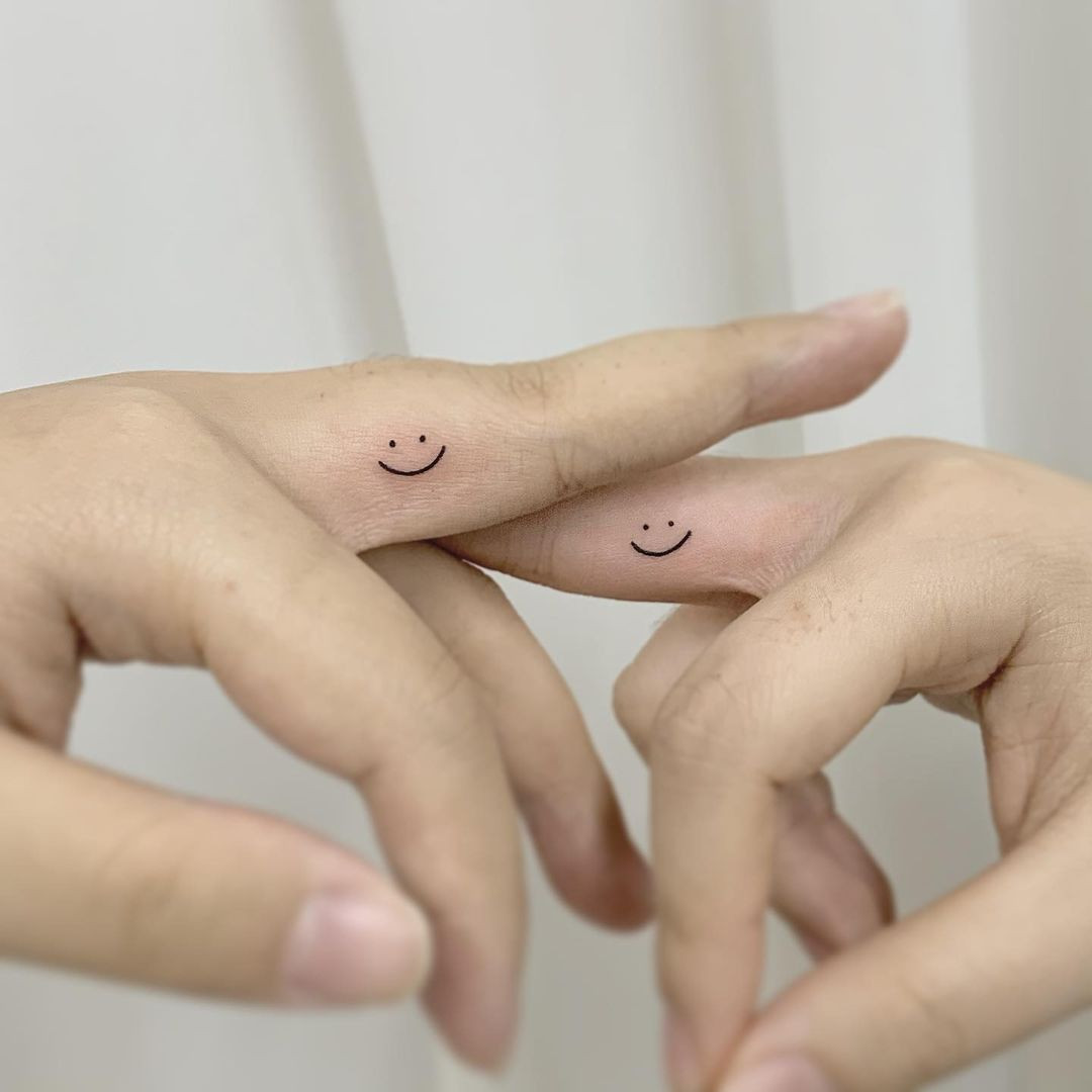 Smiley face finger tattoo for a positive vibe