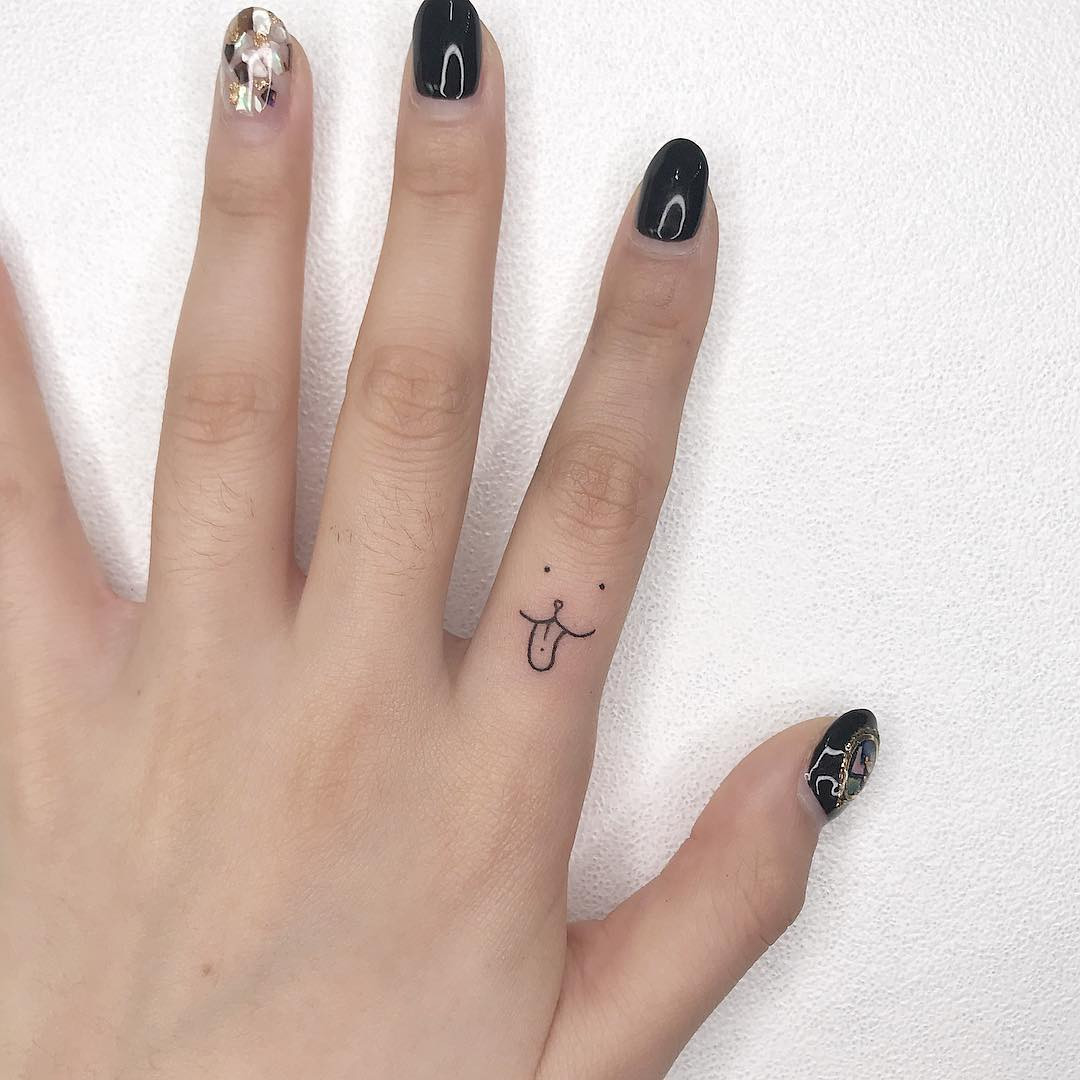 Minimalist dog paw finger tattoo