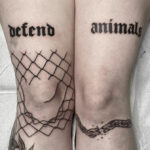 Gothic tattoo featuring stylized lettering on legs, spelling out words in a dark and elegant font.