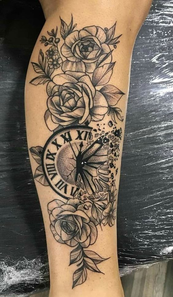 Black and grey tattoo of roses and a broken clock with Roman numerals on the forearm, symbolizing beauty and time.