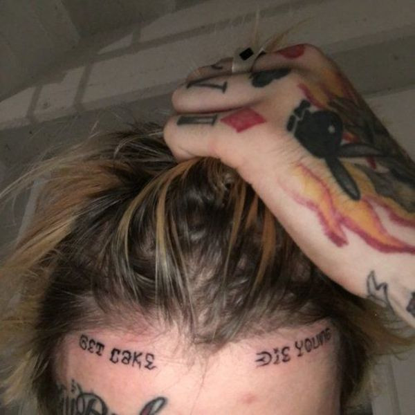 Lil Peep's forehead tattoo "Get Cake Die Young" in bold black lettering.