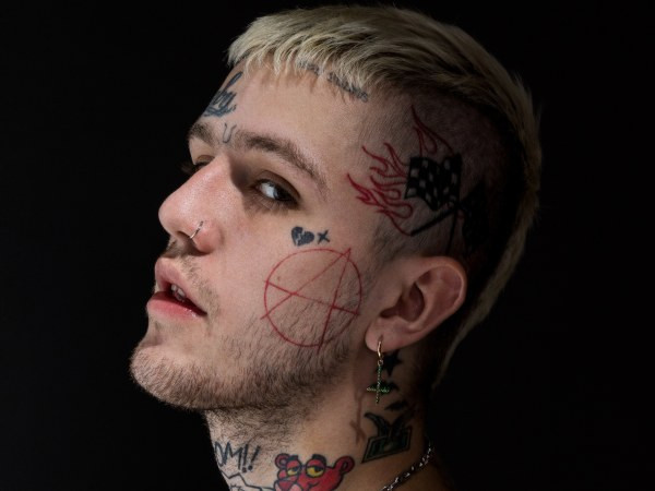 Lil Peep's head tattoos featuring racing flags, a broken heart, a cross, and an anarchy symbol.