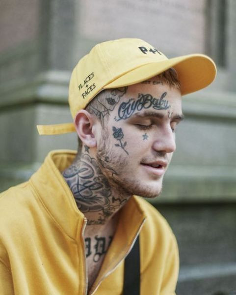 Close up of Lil Peep's face tattoos including &quot;Cry Baby&quot;, a rose, a star, and a horseshoe.