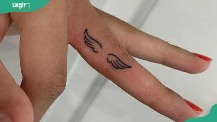 Angel wings wedding ring tattoo symbolizing protection, guidance, and everlasting love.