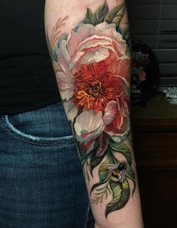 Arm tattoo featuring a detailed orange and white peony with leaves, accompanied by a realistic bee on the forearm.