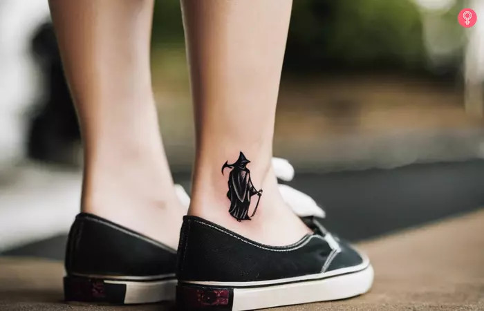 Small Grim Reaper tattoo on the ankle, a micro design featuring the back of a reaper walking forward with a scythe and billowing cloak, symbolizing life's uncertainties, hardships, and seizing opportunities.