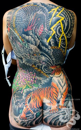 Dragon, tiger, and Chrysanthemum back piece tattoo by Kian Horisumi Forreal, an elaborate back piece featuring a dragon, tiger, and chrysanthemums, blending strength, courage, and imperial symbolism.