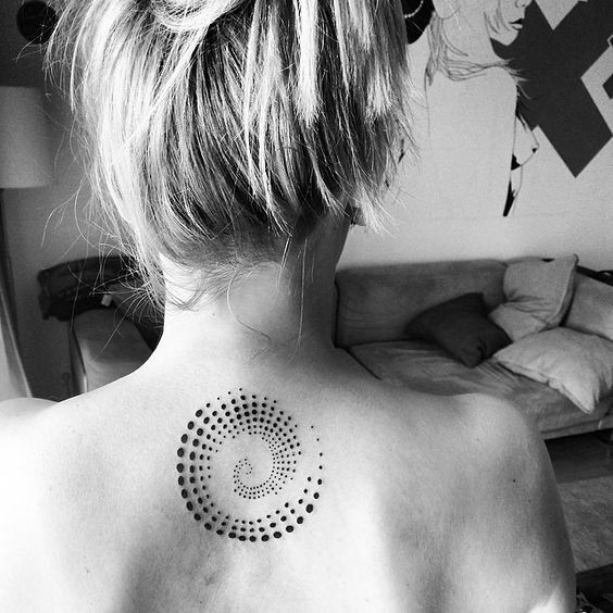 Double spiral tattoo on shoulder, symbolizing continuous growth and self-awareness