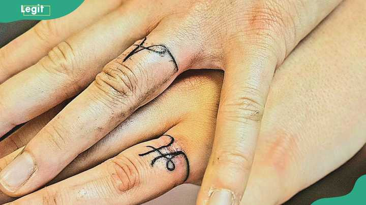 Names initials ring tattoos as a personal reminder of a partner's presence.
