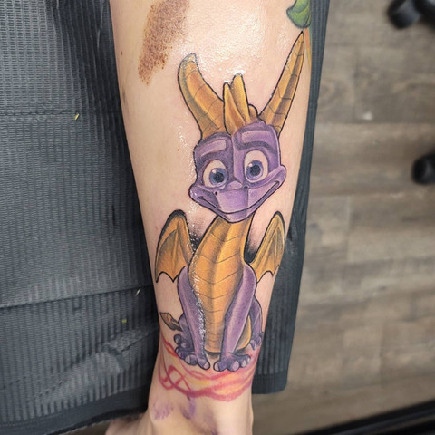 Colorful tattoo of Spyro the Dragon video game character by Joe Dillon