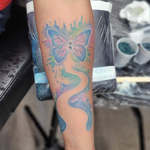 Soft watercolor style butterfly tattoo by Jenna Totten, exemplifying delicate ink therapy