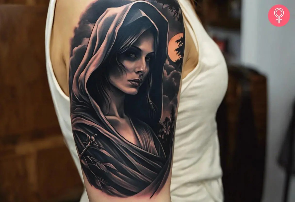 Female Grim Reaper tattoo on a woman's upper arm, showcasing a realistic style with a solemn expression, black cloak, cloudy landscape, trees, and a partially hidden full moon, representing resilience and mystery.