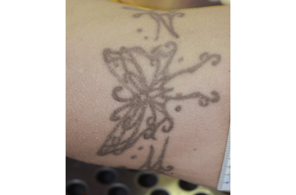 Butterfly tattoo on the upper right arm, a classic placement showcasing a simple yet elegant design for women.