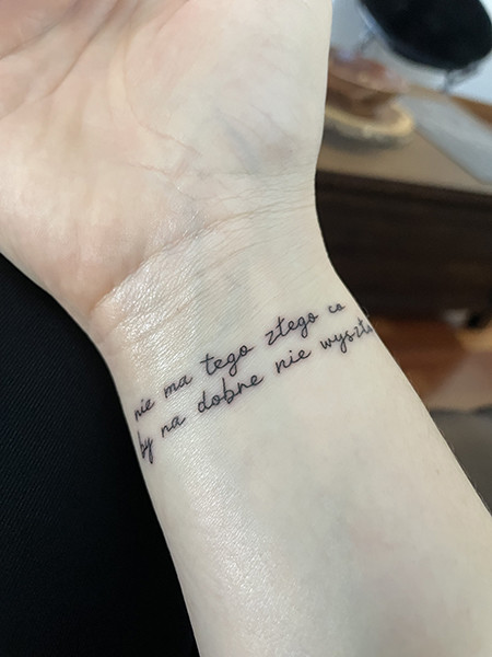 Tattoo of Polish proverb &quot;Po każdej burzy...&quot; meaning &quot;After every storm...sun shines&quot; on Alex N.'s wrist, symbolizing positivity and resilience.