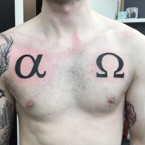 Alpha and Omega symbol tattoo on a man's wrist