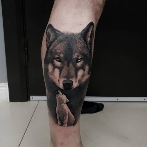 An alpha wolf tattoo on a man's shoulder, depicting a strong and confident wolf, symbolizing leadership qualities, family orientation, and a protective nature.