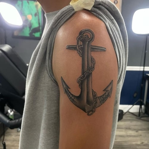 Modern anchor tattoo with rope on the arm, showcasing nautical men tattoo ideas.