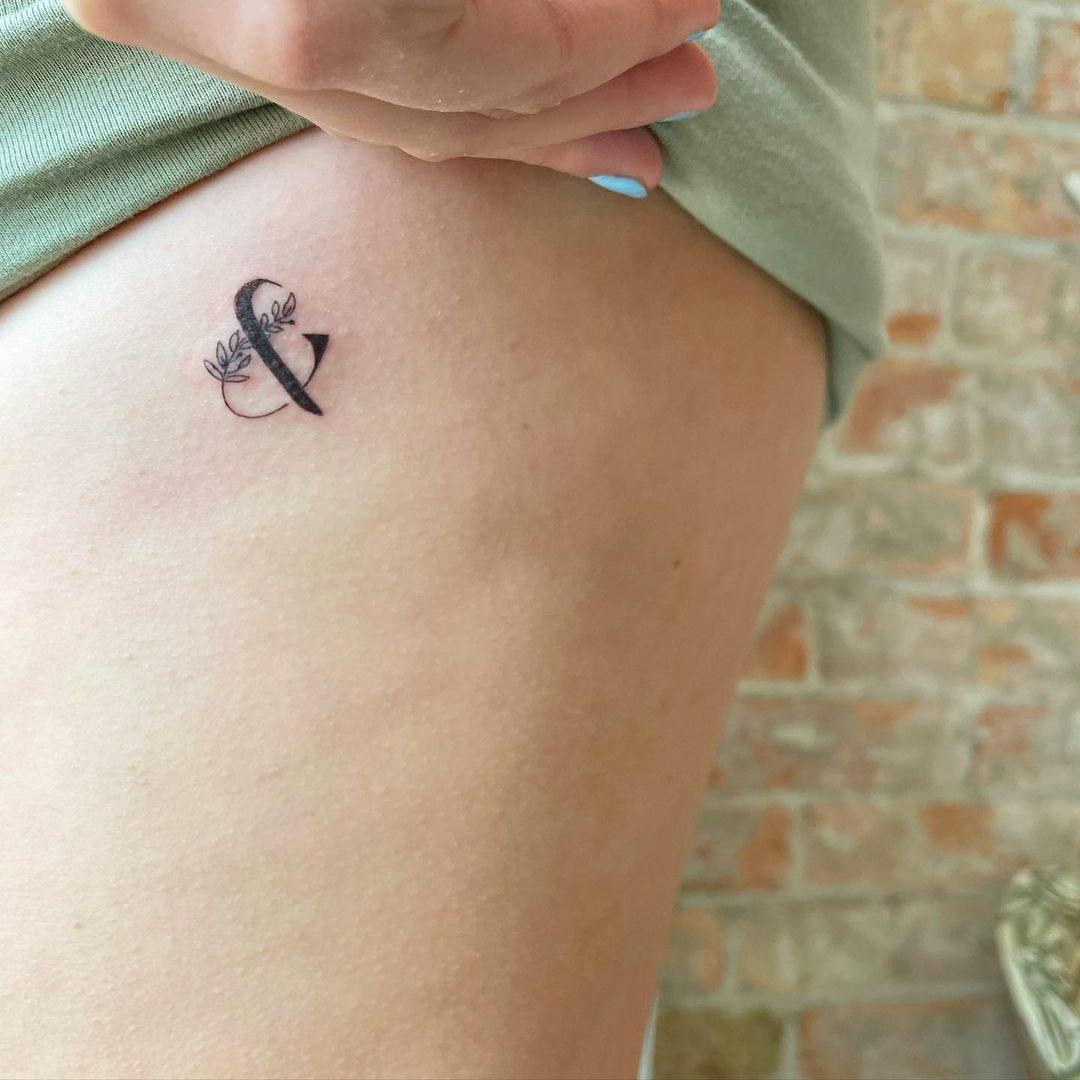 Ampersand symbol miscarriage tattoo on wrist.