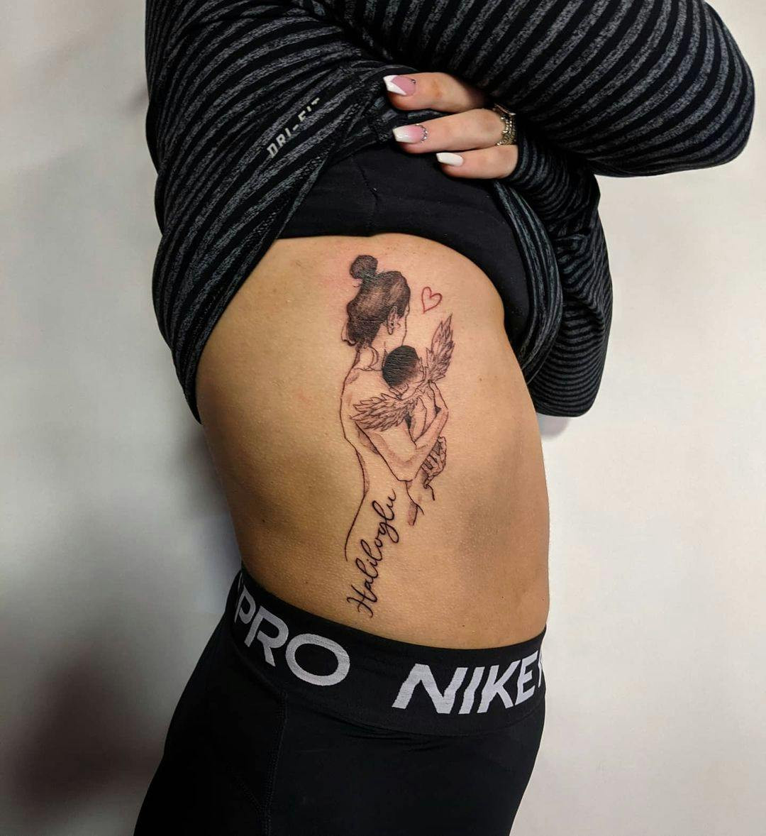 Mother holding angel baby miscarriage tattoo on arm.