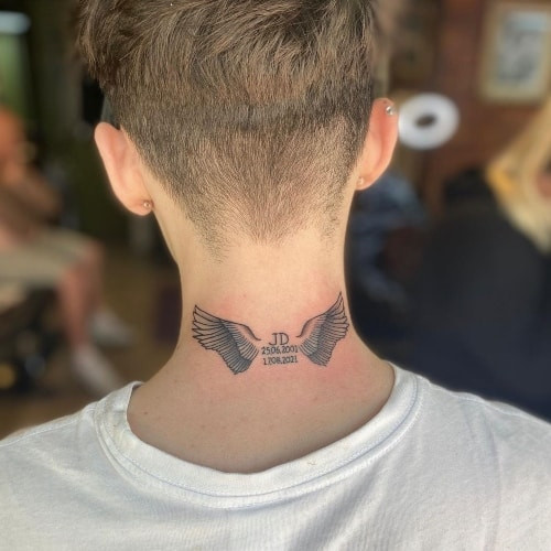 An angel wings tattoo on a man's back, extending across the shoulders