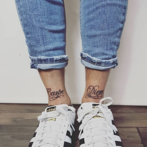 An ankle tattoo with minimalist symbols on a man's lower leg, subtle and trendy