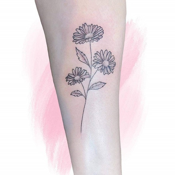 Small, minimalist aster flower outline tattoo in black ink, placed behind the ear.