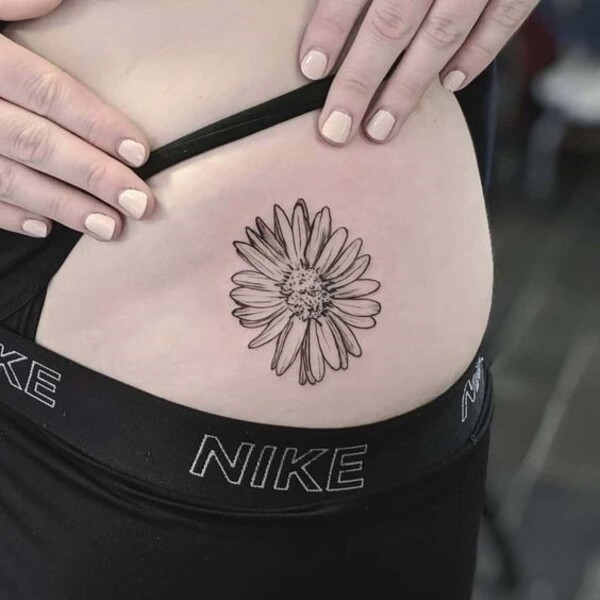 Dotwork aster flower tattoo with intricate stippling for shading, creating a delicate look, on the wrist.